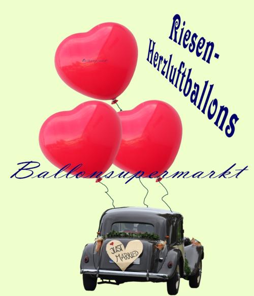 Mit Riesen-Herzluftballons am Hochzeitsauto auf der Fahrt in das Hochzeitsglück